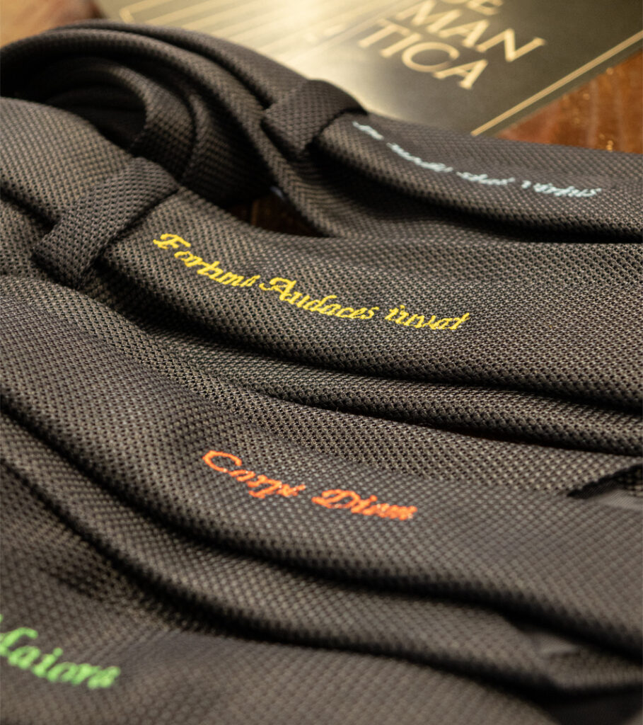 photo of some ties from the new Semantic collection, with embroidery of the motto on the tie tail